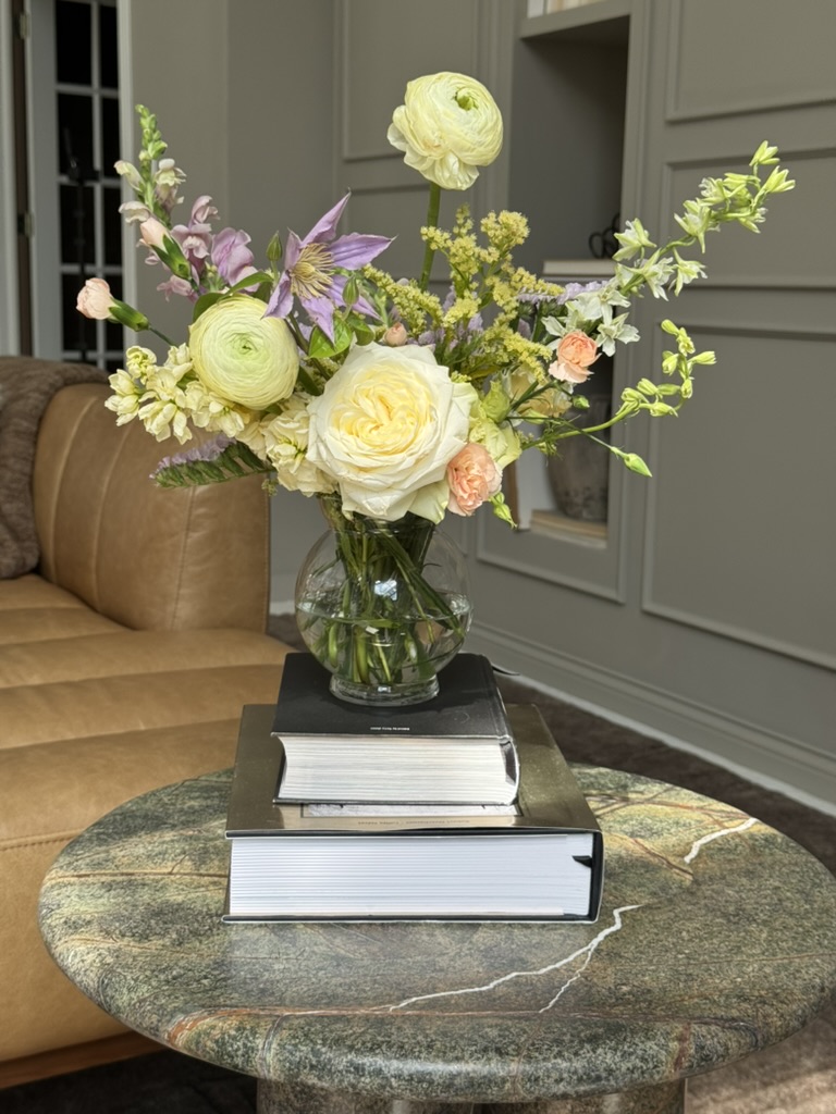 Detail of a spring corporate arrangement with anemones, daffodils, and peach roses